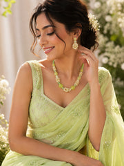 MoRa Dream lime green and mint green beaded necklace with matching floral cluster earrings, pearl-style accents, and gold-tone details displayed on a white background with green and yellow satin fabric